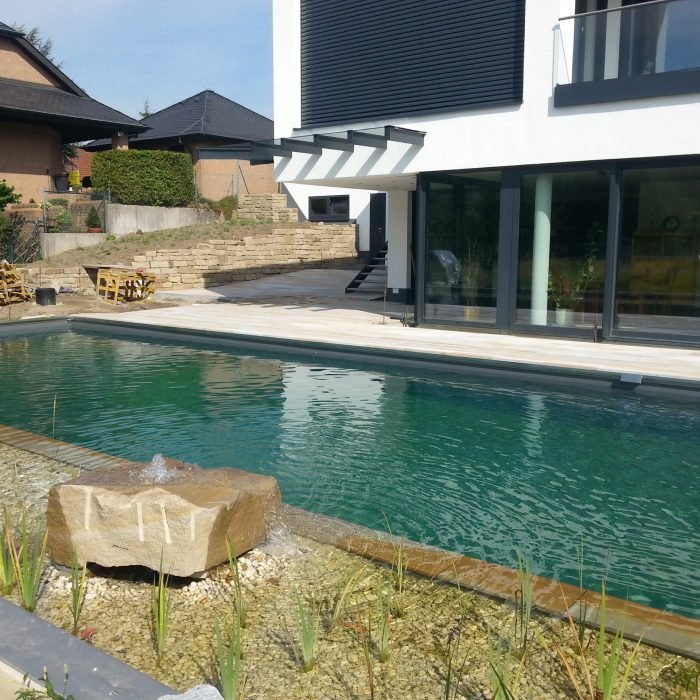 Schwimmteich mit Quellstein und Sandstein-Umrandung